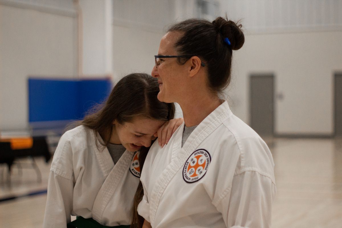 Instructor and student sharing a laugh together in the dojo after training